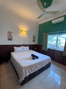 a bedroom with a large white bed with a fan at Leaf Boutique SR in Siem Reap