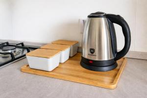 a tea kettle on a wooden stand next to a stove at Valley View in Qrendi