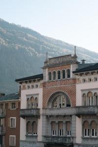a large brick building with a mountain in the background at Tower Double Suite - 3 min walk to Bernina Express in Tirano
