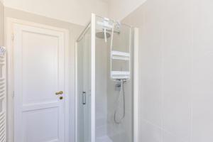 a white bathroom with a shower and a sink at La Caletta Di Luce in Lerici +13 photos