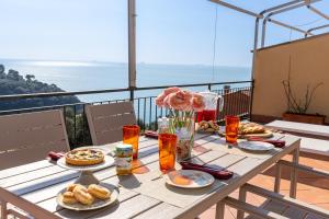 a table with plates of food on top of a balcony at La Caletta Di Luce in Lerici