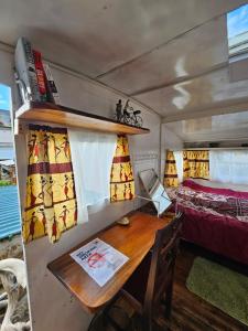 a room with a table and a bed and a desk at Ubuntu Backpackers in Umtali