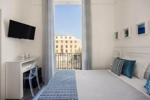 a bedroom with a bed and a tv and a window at Archimede Charm B&B - Historical Palace in Ortigia in Syracuse +81 photos