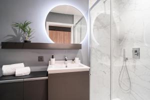 a bathroom with a sink and a mirror at City Pop 2Night Geneva - Self check-in in Geneva