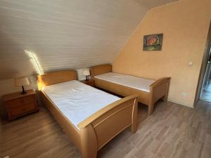 a small bedroom with two beds and a lamp at Gemütliche Ferien oder Monteurs Wohnung in Wallsbüll