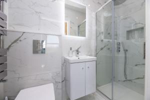 a white bathroom with a sink and a shower at Snowdonia View in Llanfairpwllgwyngyll +29 photos