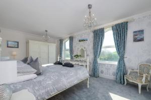 a bedroom with a large bed with blue curtains at Snowdonia View in Llanfairpwllgwyngyll