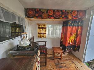 a room with a kitchen with a stove and curtains at Ubuntu Backpackers in Umtali