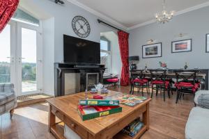 a living room with a table and a tv at Snowdonia View in Llanfairpwllgwyngyll