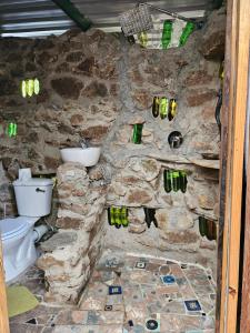a bathroom with a stone wall with a toilet at Ubuntu Backpackers in Umtali