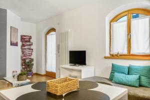 a living room with a couch and a tv at Windshouse 2 Apartments in Nago-Torbole