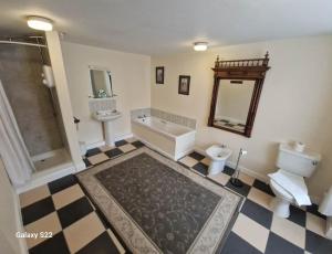 a bathroom with a tub and a toilet and a sink at Trehellas House Hotel & Courthouse restaurant in Bodmin +84 photos