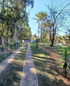 a path in a park with trees and a bridge at Chacara pais e filhas in Socorro