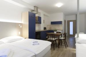 a bedroom with a bed and a kitchen with a table at Studia a apartmány U Karla in Turnov