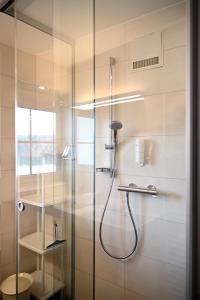 a bathroom with a shower with a glass door at Maltschacher Seewirt in Feldkirchen in Kärnten +65 photos