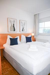 a large white bed with blue pillows in a room at Maltschacher Seewirt in Feldkirchen in Kärnten
