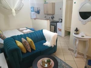 a living room with a blue couch and a kitchen at Soney Homes in Nairobi