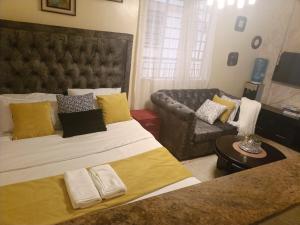 a bedroom with a large bed and a couch at Soney Homes in Nairobi