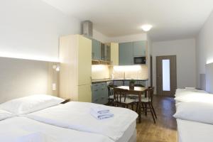 a bedroom with two beds and a kitchen with a table at Studia a apartmány U Karla in Turnov +28 photos
