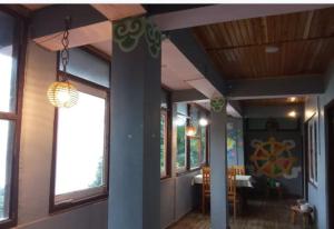 a hallway of a house with a table and windows at Rainbow Guest House in Sonāda