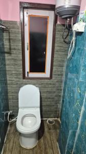 a small bathroom with a toilet and a sink at Rainbow Guest House in Sonāda