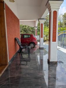 a red car parked on a porch with a chair at Veranda Villa in Angamaly