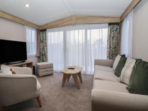 a living room with a couch and a tv at Lodge 22, Moselle in Malton