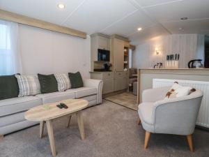 a living room with a couch and a chair and a table at Lodge 22, Moselle in Malton +7 photos