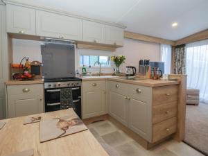 a kitchen with white cabinets and a stove top oven at Lodge 22, Moselle in Malton