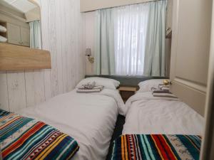 two beds in a small room with a window at Lodge 22, Moselle in Malton