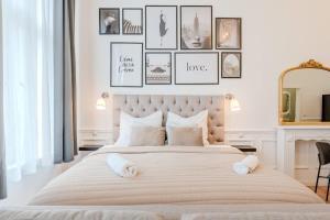 a bedroom with a large bed with framed pictures on the wall at Prenzlauer Berg Prestige in Berlin
