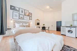a white bedroom with two beds and a washing machine at Prenzlauer Berg Prestige in Berlin