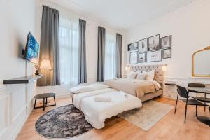 a white bedroom with a large bed and a table at Prenzlauer Berg Prestige in Berlin