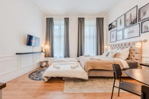 a white bedroom with a large bed and a table at Prenzlauer Berg Prestige in Berlin