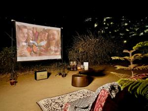 a large projection screen with a group of people on it at The Bay Leaf Resort in Shimla +5 photos