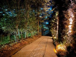 a walkway in a park at night with trees at The Bay Leaf Resort in Shimla