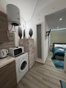 a kitchen with a washing machine and a microwave at Spataro Home in Catania