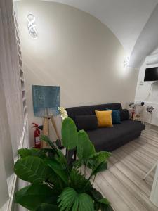 a living room with a black couch in a room at Spataro Home in Catania