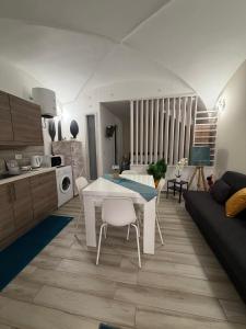 a kitchen and living room with a white table and chairs at Spataro Home in Catania