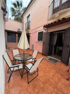 a patio with a table and chairs and a umbrella at Spataro Home in Catania