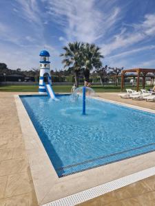 a swimming pool with a lighthouse and a slide at Camping Platja Cambrils in Cambrils