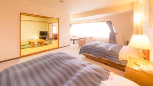 a bedroom with two beds and a large mirror at グリーンピア三陸みやこ in Miyako