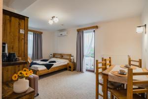 a hotel room with a bed and a table and chairs at Perła Beskidu in Ustroń