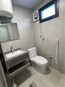 a bathroom with a toilet and a sink and a window at سويتات الباديه in Dammam