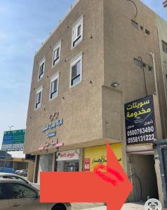 a building with a red arrow in front of it at سويتات الباديه in Dammam