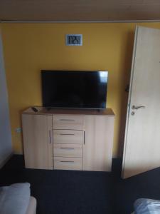 a flat screen tv on a cabinet in a bedroom at Ferienwohnung Haske mit Wallbox in Gifhorn
