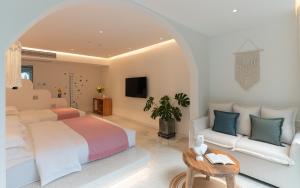 a white bedroom with a bed and a couch at Yangshuo MINOS Hotel-Inspired by Santorini design, Entrance of Ten-Mile Gallery,Free Laundry,Itinerary Hepler,Book Tickets in Advance,E Scooter Service in Yangshuo