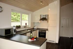 a kitchen with a counter with a sink and a microwave at Ferienhaus Grafschafter Perle in Nordhorn