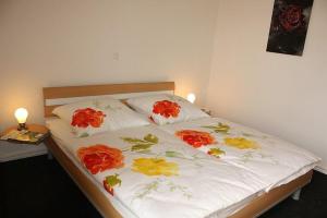 a bed with red and yellow flowers on it at Ferienhaus Grafschafter Perle in Nordhorn