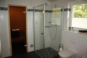 a bathroom with a shower and a toilet at Ferienhaus Grafschafter Perle in Nordhorn +2 photos